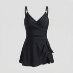 Black one-piece swimdress with surplice bust, ruched tummy control, tie-front skirt, straps