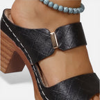 Black leather block heel sandal close-up of buckle strap and textured footbed