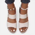 Beige leather block heel sandals with open toe, ankle bead bracelet, and wide strap