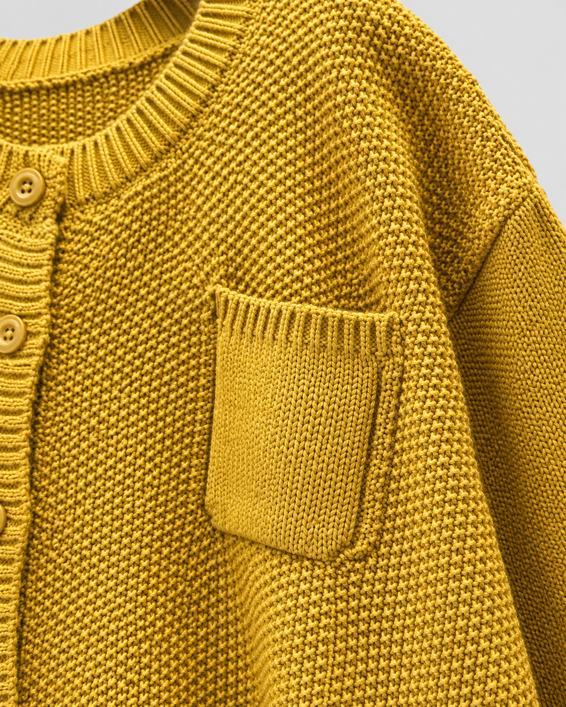 Yellow knit cardigan with front pocket and ribbed knit texture