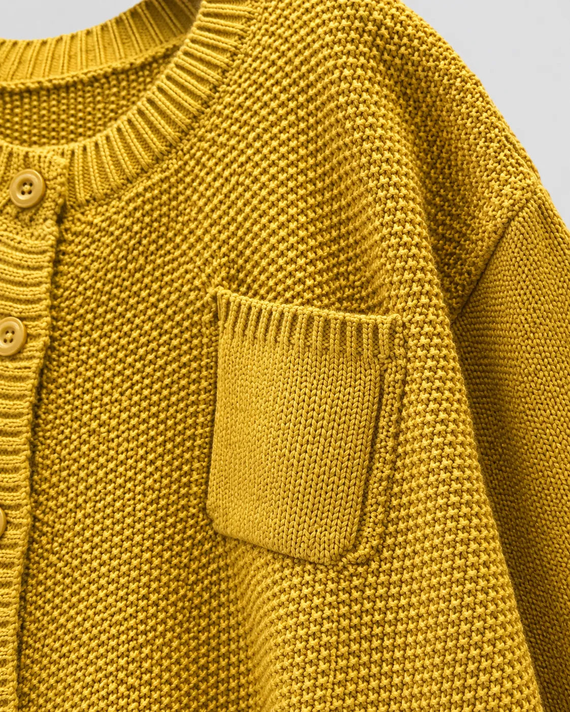 Yellow knit cardigan with front pocket and ribbed knit texture