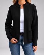 Black open-front knit cardigan with long sleeves, patch pockets, and zipper front