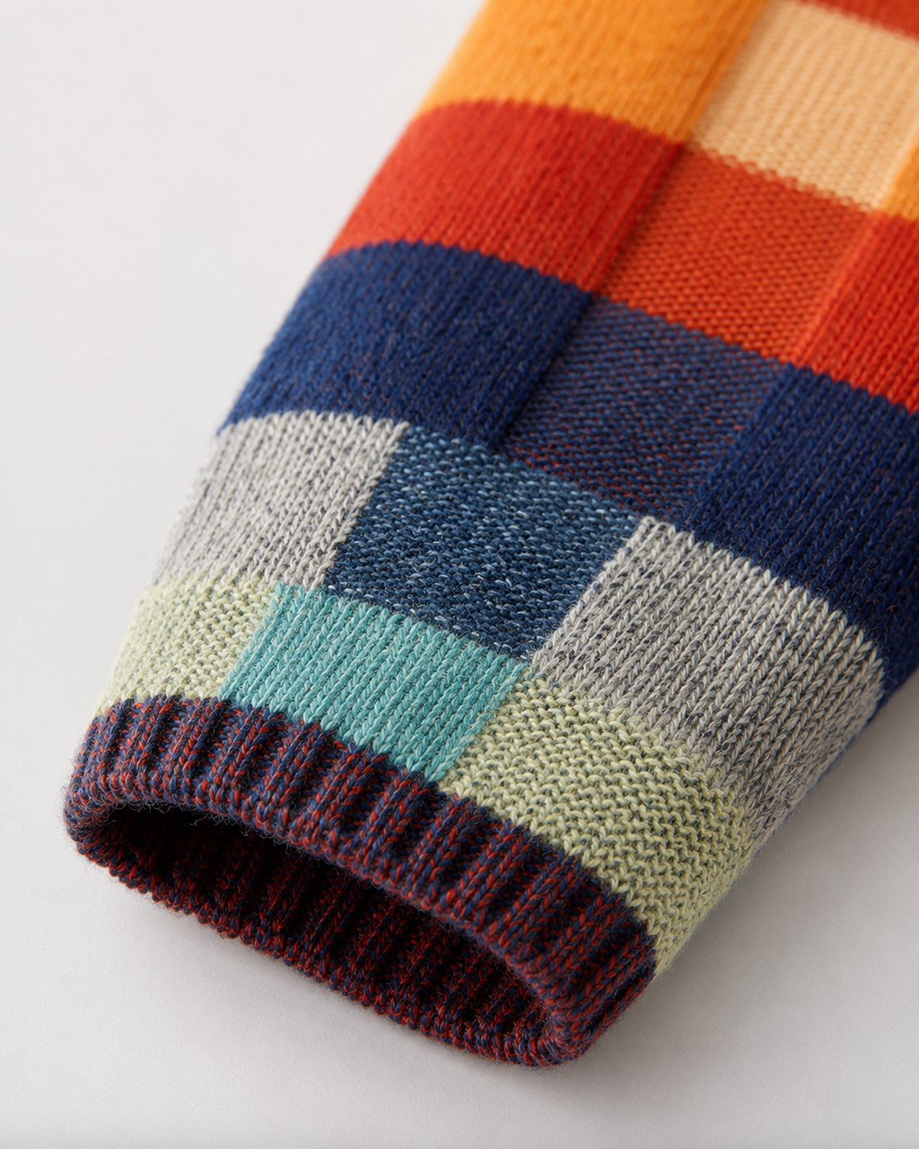 Close-up of multicolor check knit sleeve cuff with ribbed trim