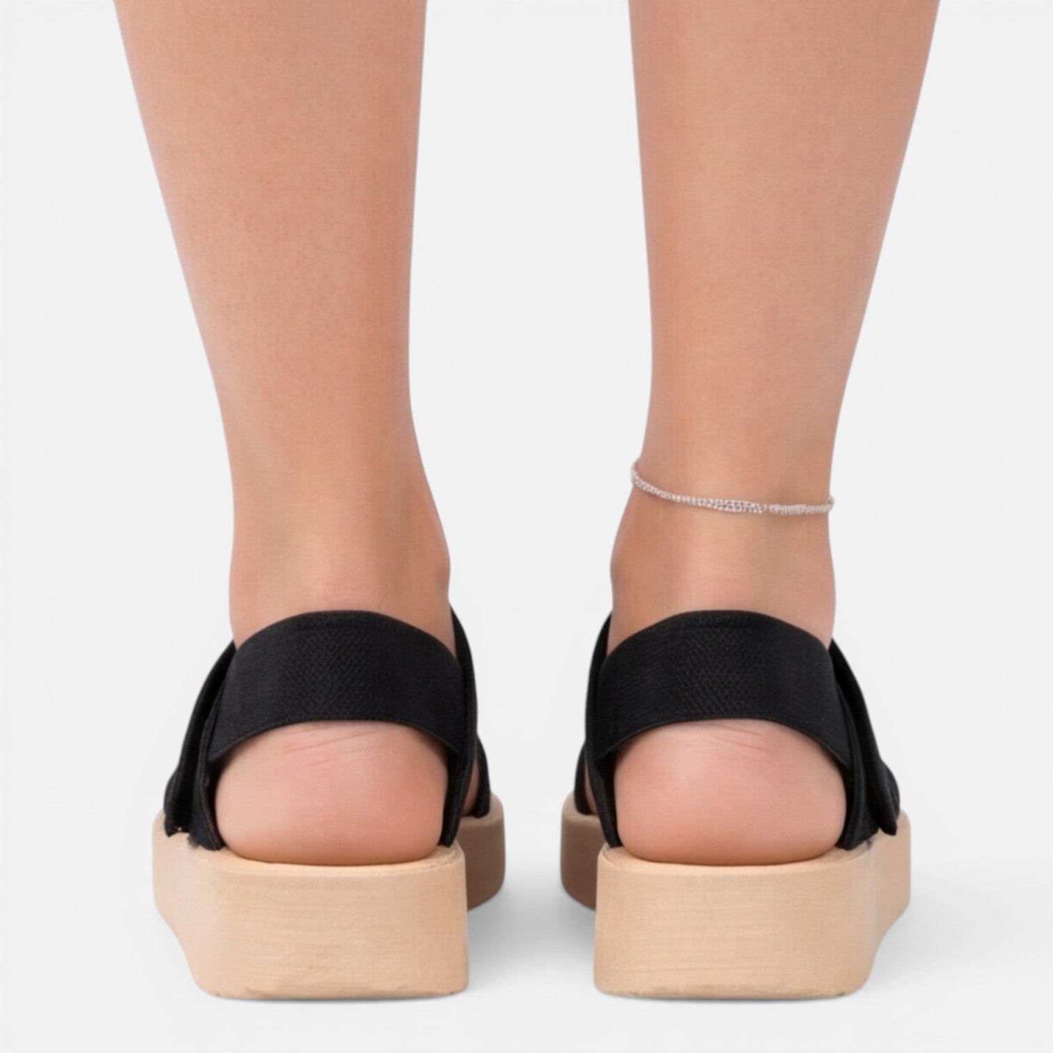Women’s wedge sandals in black shown from the back with ankle bracelet