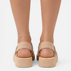 Women’s wedge sandals in beige from back view with ankle bracelet