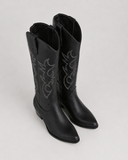 Black knee-high cowboy boots with embroidered side scrolls and pull-on shaft
