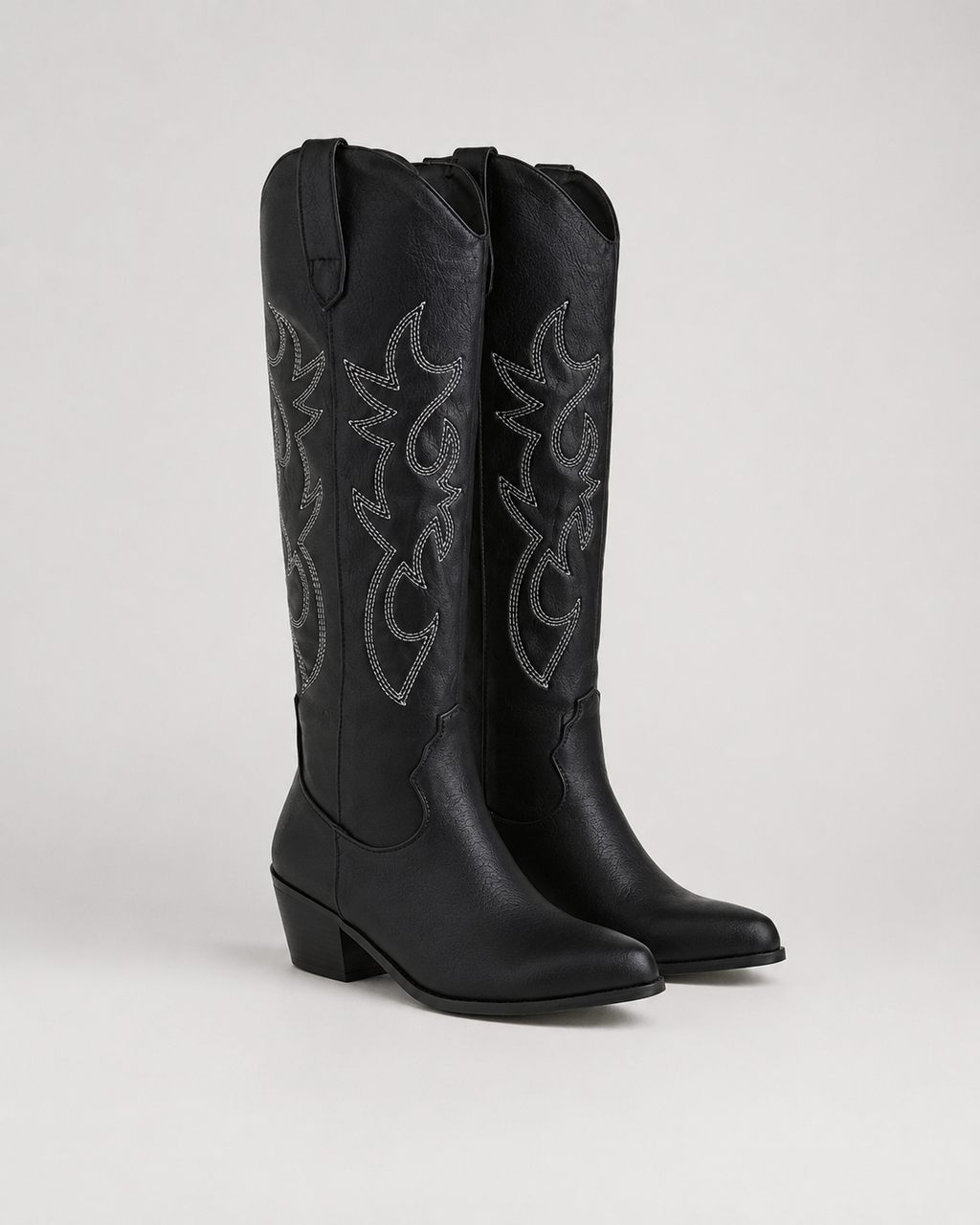 Black knee-high cowboy boots with embroidered scroll panels and low block heel