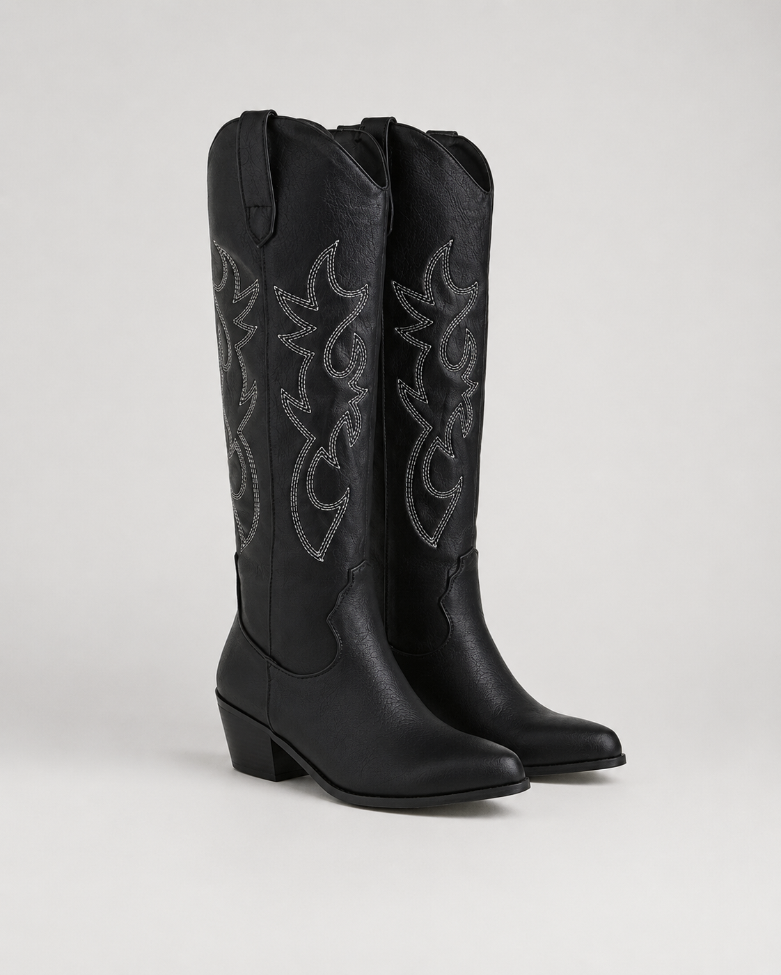 Black knee-high cowboy boots with embroidered scroll panels and low block heel