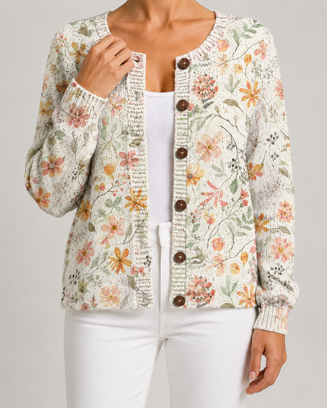 Cream floral knit cardigan with pastel blossoms, button-front with round dark buttons and ribbed cuffs.