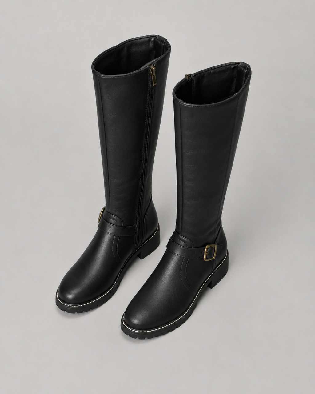 Black knee-high buckle boots with side zip and lug sole, angled side pair view.