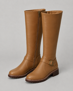 Brown knee-high buckle boots with side zip and lug sole, front pair view.