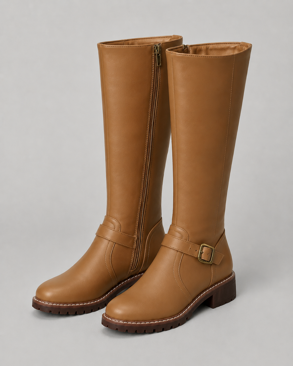 Brown knee-high buckle boots with side zip and lug sole, front pair view.