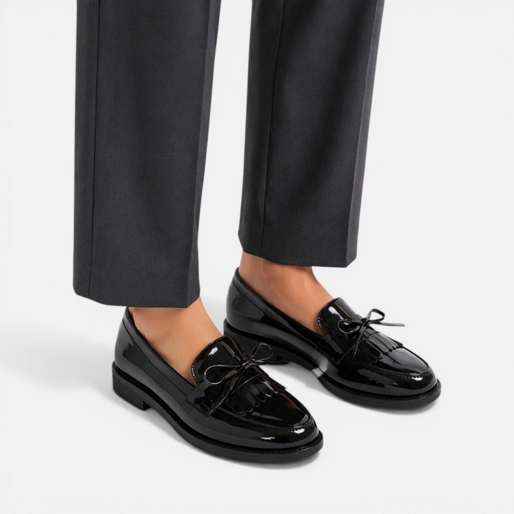 Black patent loafers with decorative tassels and strap, low block heel
