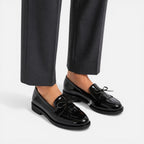 Black patent loafers with decorative tassels and strap, low block heel