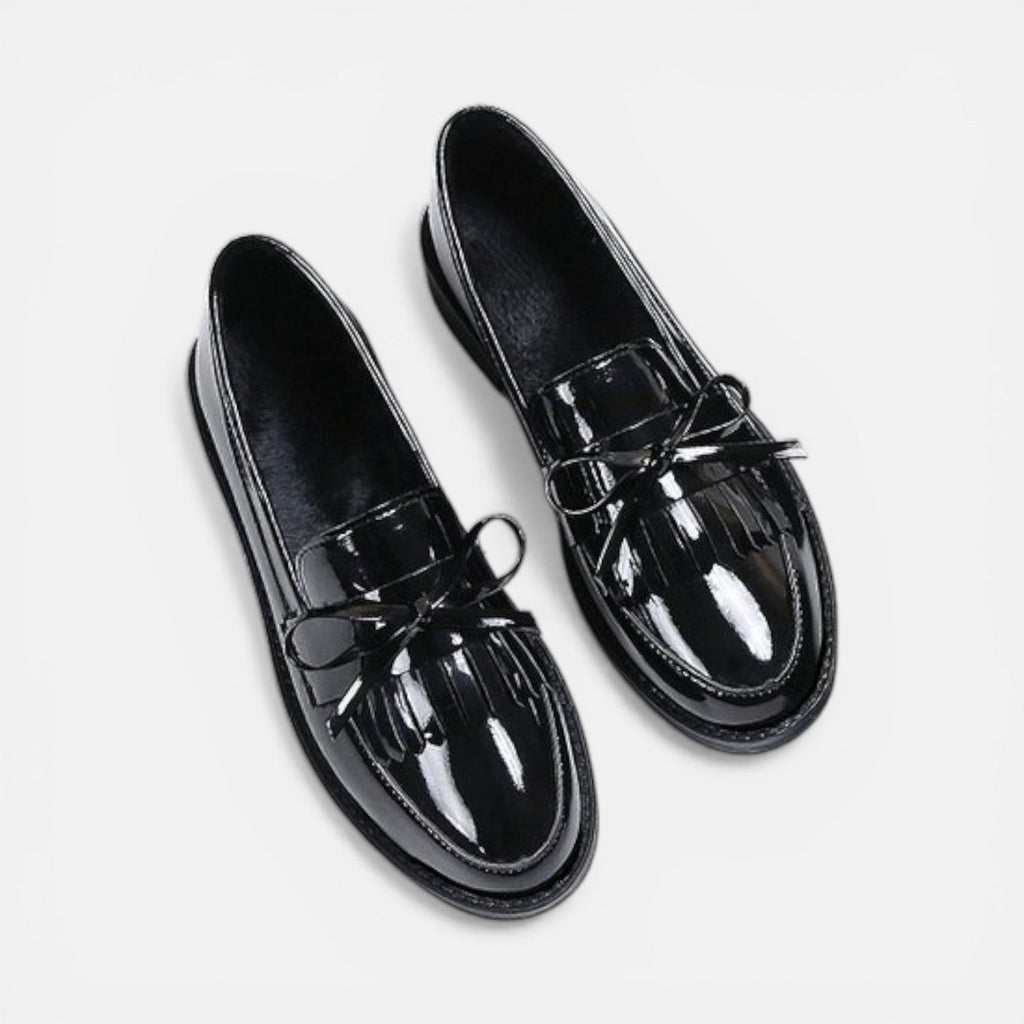 Black patent loafers with tassel detail and slip-on strap, round toe