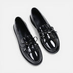 Black patent loafers with tassel detail and slip-on strap, round toe