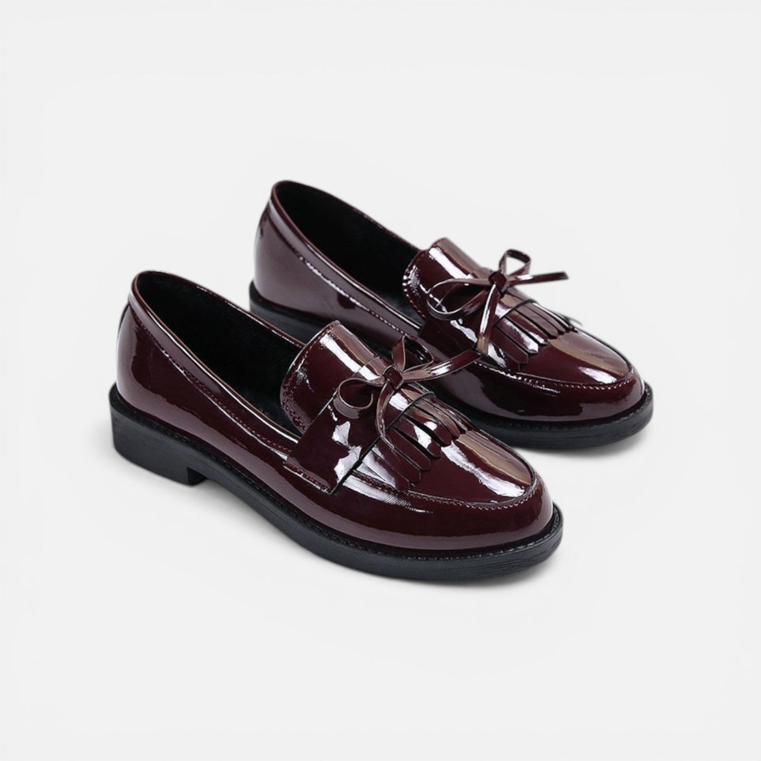 Burgundy patent slip-on loafers with tassel fringe and round toe, low heel