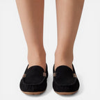 Women’s slip-on loafers in black suede with gold-tone metal buckle and stitched edge