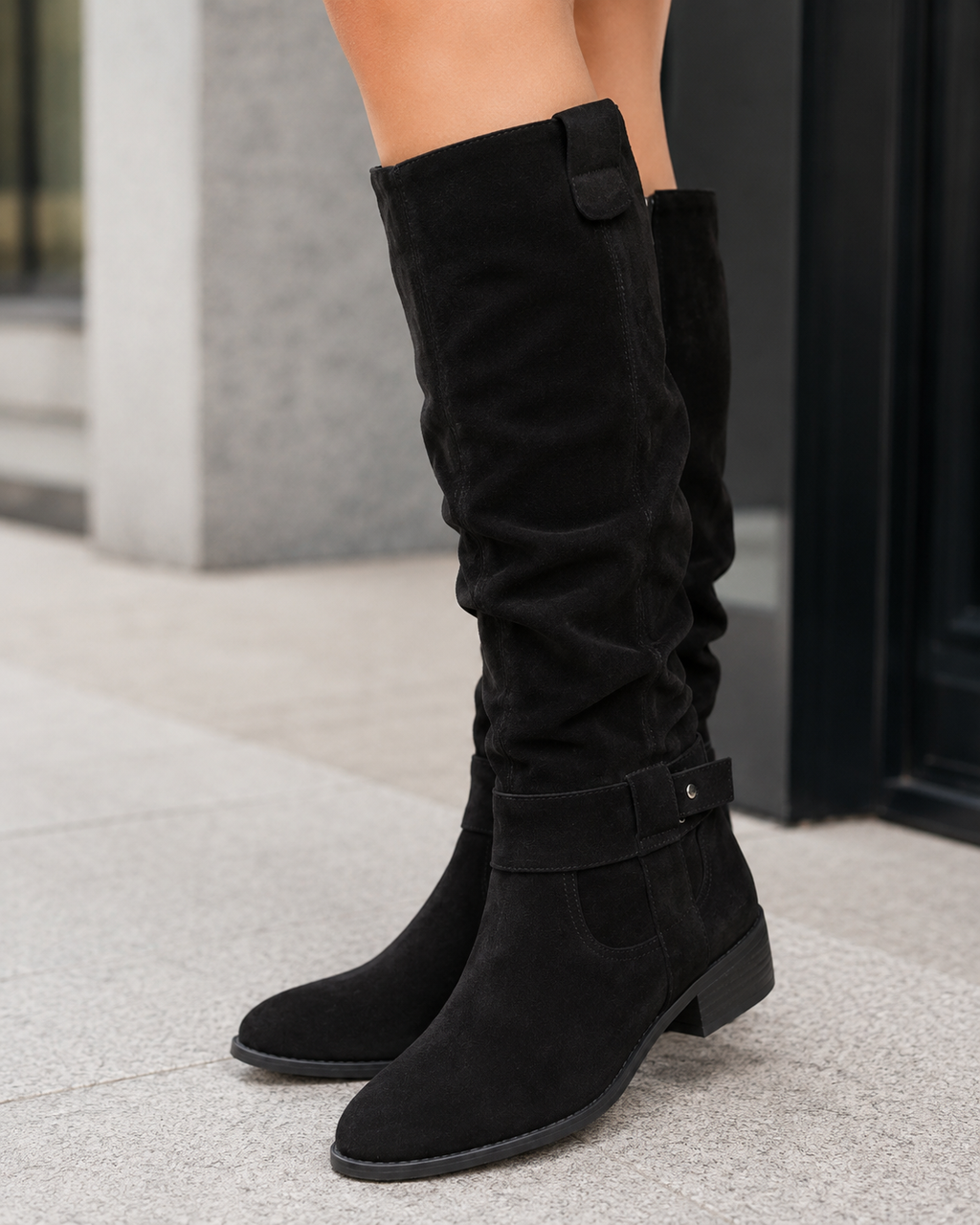 Black suede knee-high boots with low heel and side zip closure