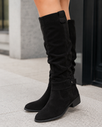 Black suede knee-high boots with low heel and side zip closure