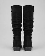 Pair of black suede knee-high boots with buckle strap at shaft