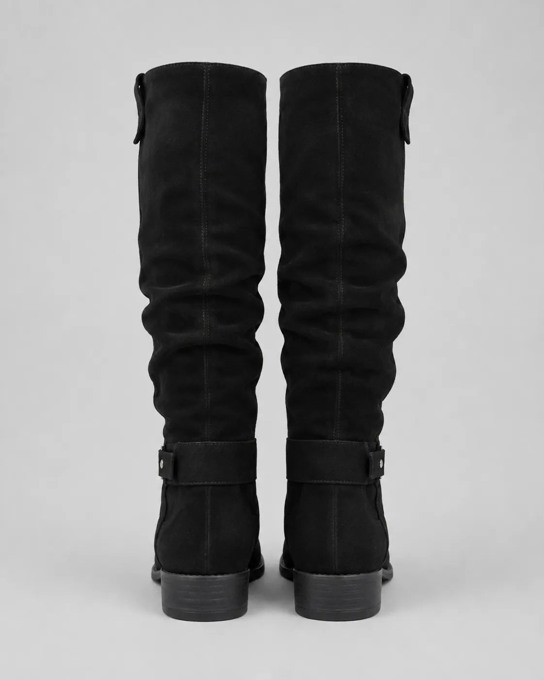 Pair of black suede knee-high boots with buckle strap at shaft