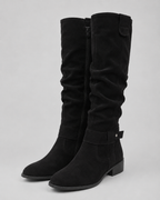 Black suede knee-high boots with low heel, side zip, and top pull tab