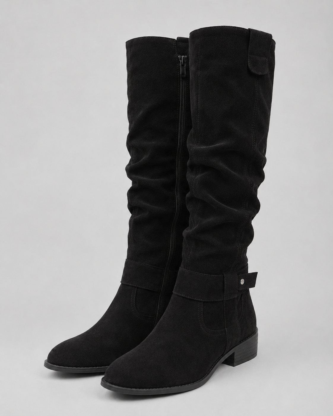 Black suede knee-high boots with low heel, side zip, and top pull tab