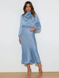 Light blue satin midi dress with long sleeves, high neck, and gathered neckline