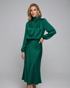 Emerald green satin midi dress with long sleeves, high neckline, and gathered waist