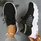 Women's sneakers with black mesh knit upper, lace-up, white tread sole and yellow stripe.