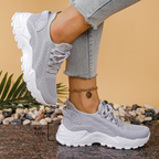 Women's sneakers in light gray mesh with lace-up, cushioned chunky white tread sole.