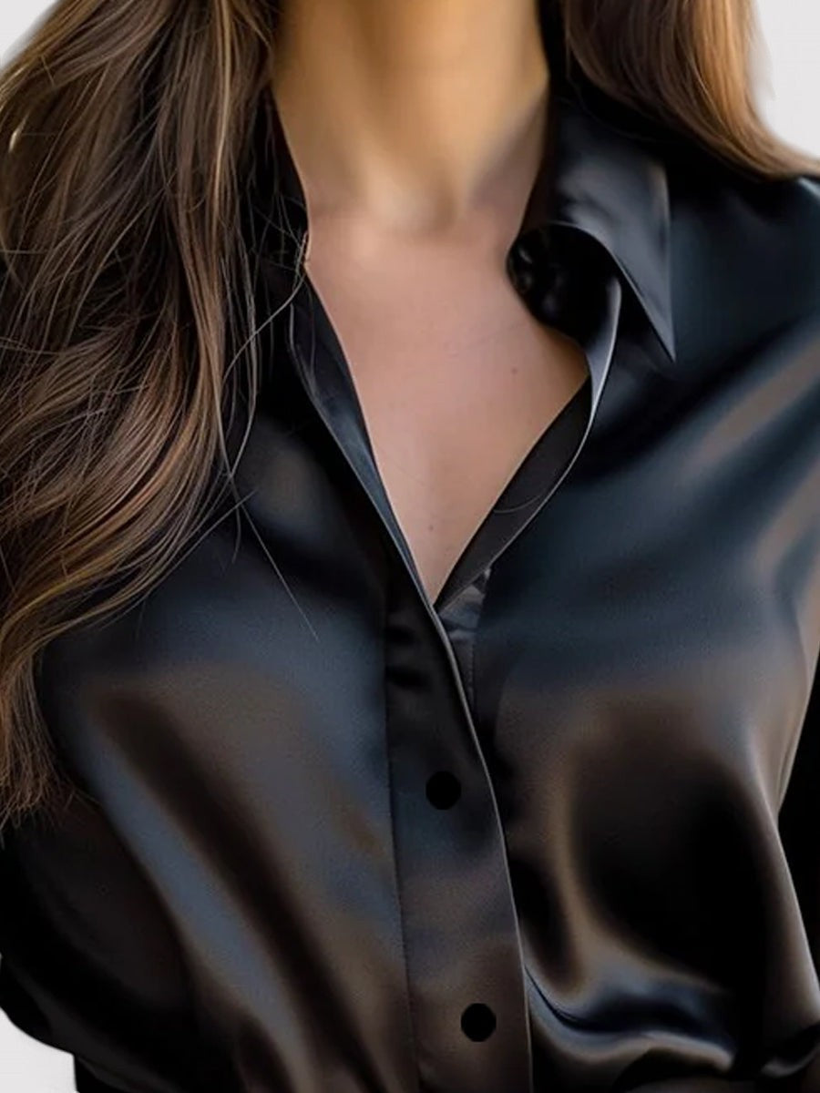 Black satin long-sleeve blouse close-up showing V neckline and button front