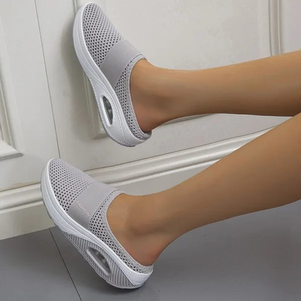Light grey backless slip-on knit sneakers with white sole and oval side detail