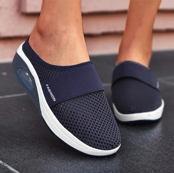 Navy backless slip-on knit sneakers with white sole and oval side detail