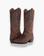 Brown cowboy boots with ornate cutout-style stitching and block heel
