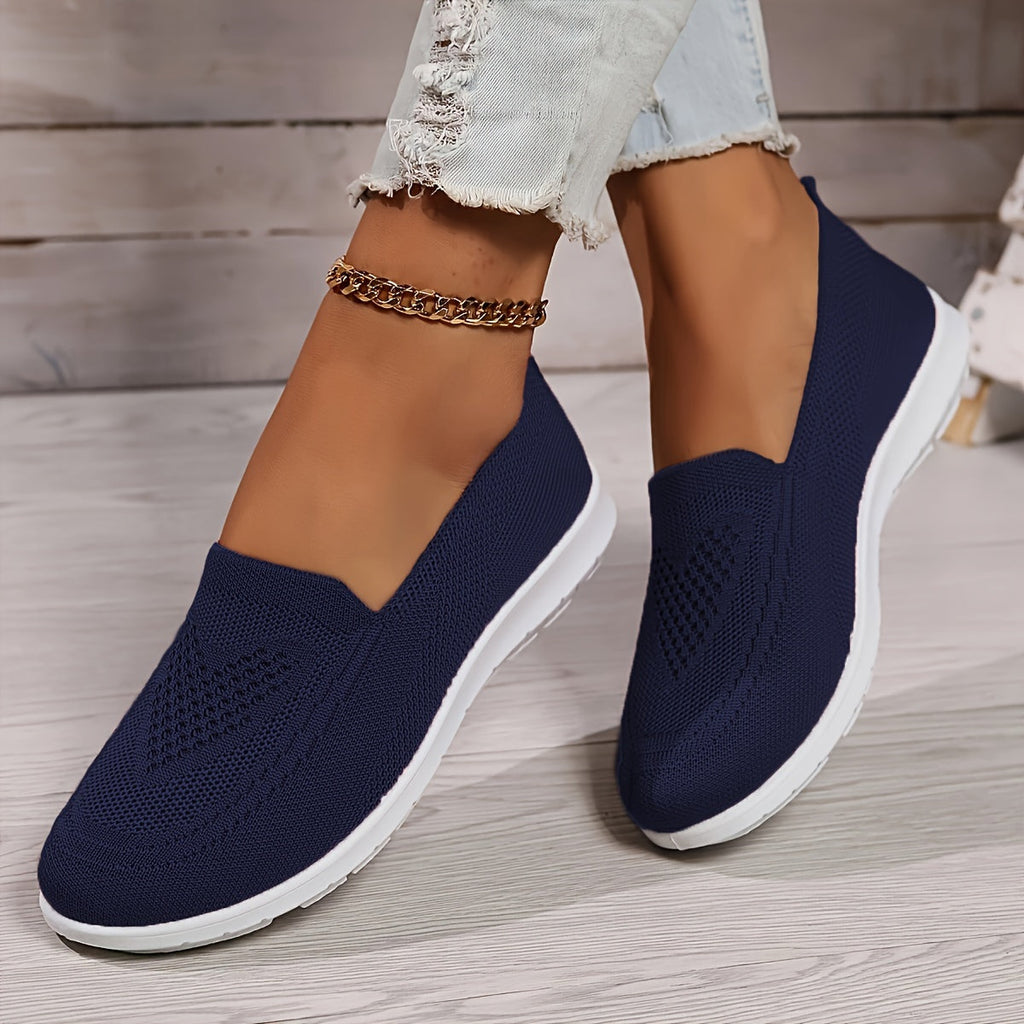 Navy low-top slip-on sneakers with textured knit upper and white rubber sole.