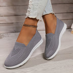 Grey low-top slip-on sneakers with textured knit upper and white rubber sole.