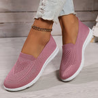 Pink low-top slip-on sneakers with textured knit upper and white rubber sole.