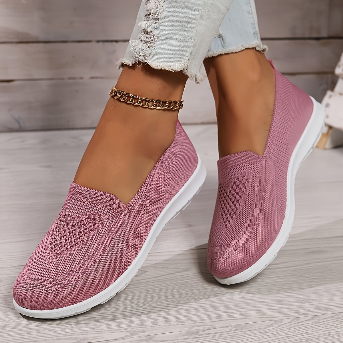 Pink low-top slip-on sneakers with textured knit upper and white rubber sole.