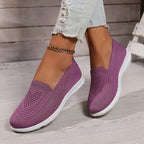 Fuchsia low-top slip-on sneakers with textured knit upper and white rubber sole.