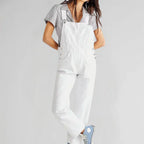 White denim jumpsuit with square neckline, bib front, and front pocket details