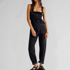 Black denim sleeveless jumpsuit with square neck, front pocket bib, and wide legs