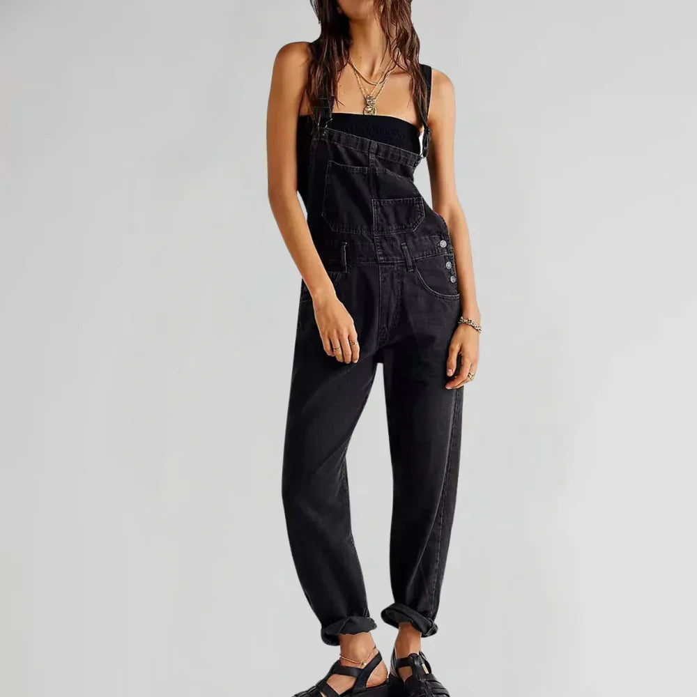 Black denim sleeveless jumpsuit with square neck, front pocket bib, and wide legs