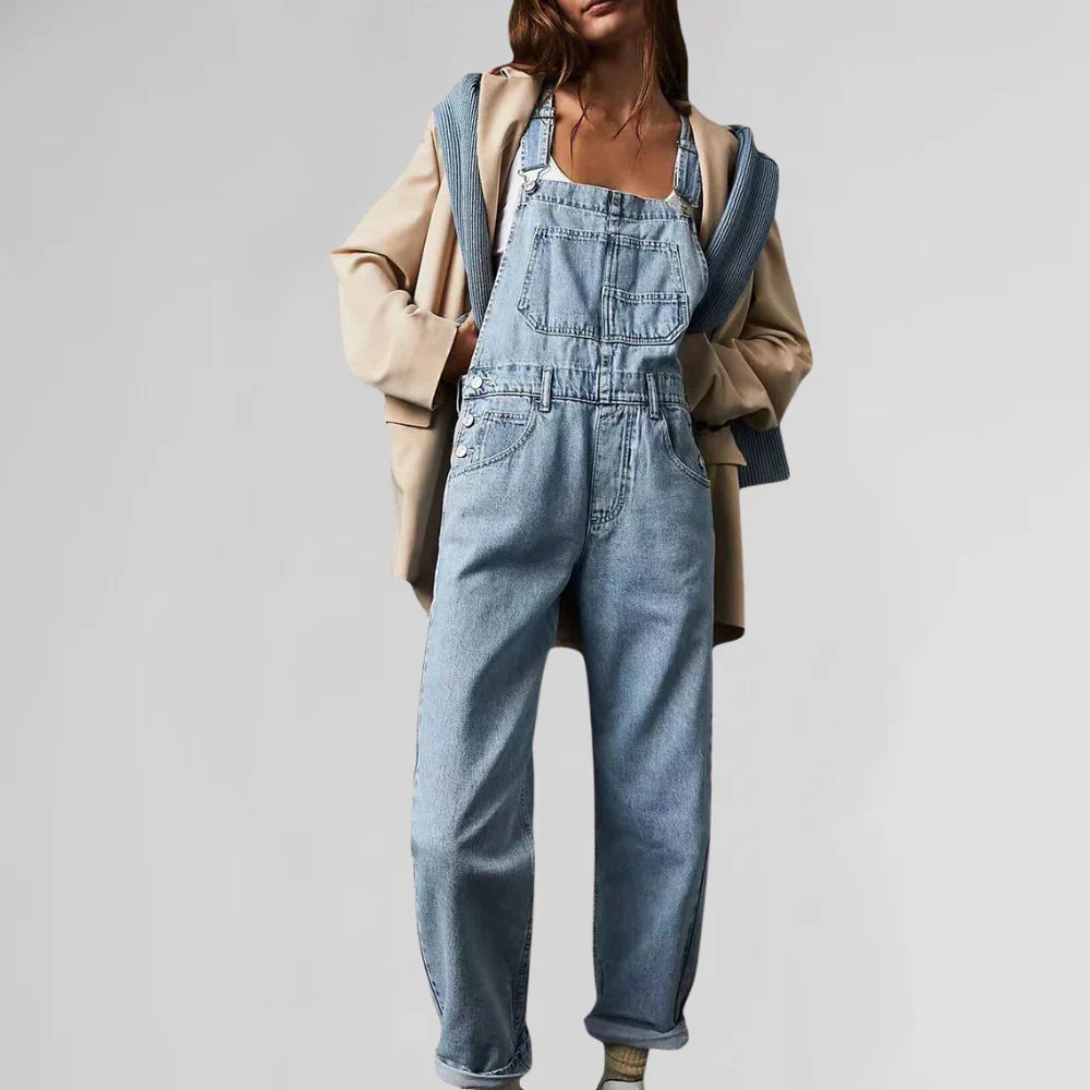 Light blue denim jumpsuit with square neck, bib front pockets, and wide-leg legs
