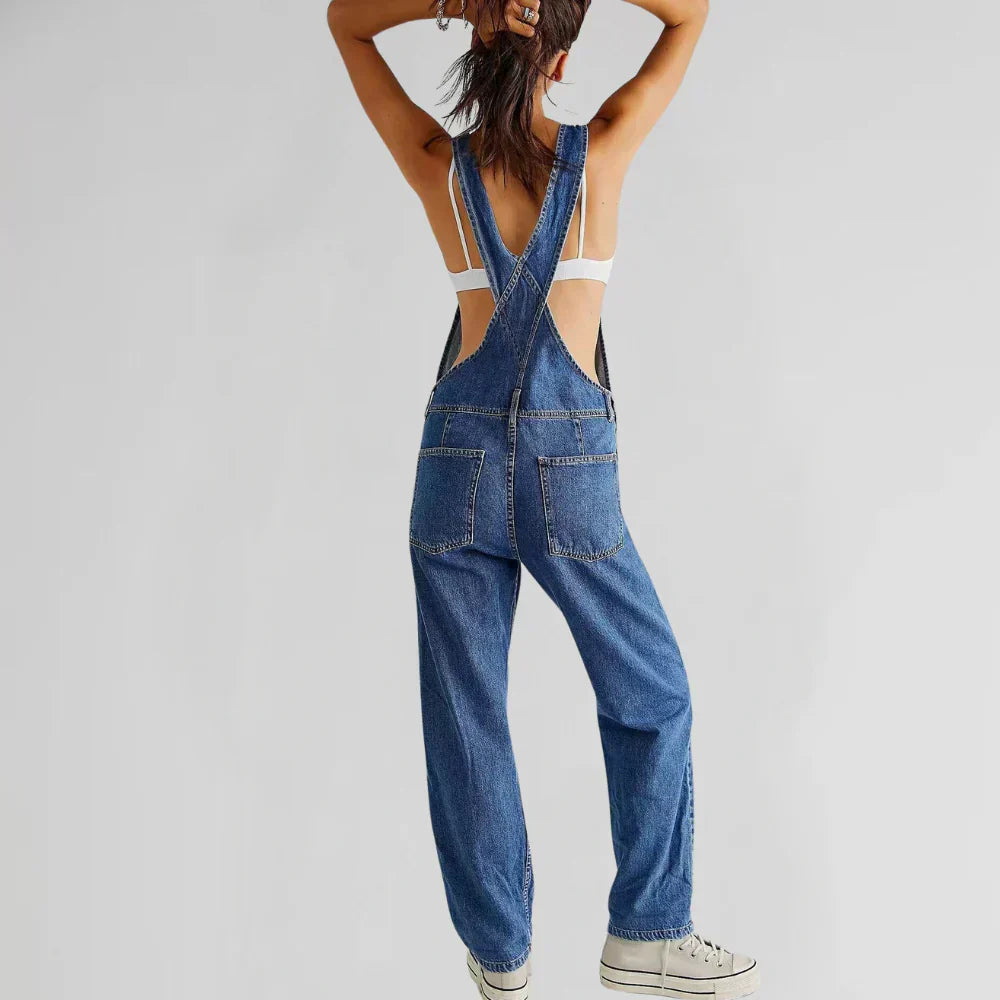 Blue denim sleeveless jumpsuit with square neck, front pockets, and wide legs