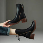 Black ankle boots with block heel and side zipper detail, close-up