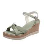 Light green platform wedge sandal with ankle strap and round buckle, open toe