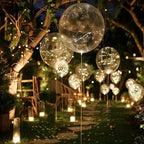 Warm white LED transparent balloons floating outdoors with glowing light strings