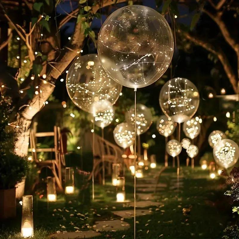 Warm white LED transparent balloons floating outdoors with glowing light strings